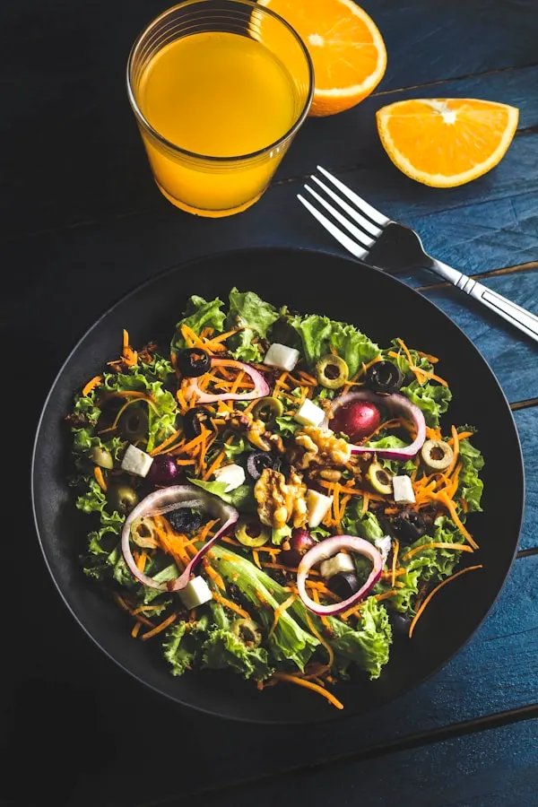 Avocado crunch wrap sliced diagonally and plated on parchment paper showing layers of fresh avocado, crisp vegetables, and lime crema